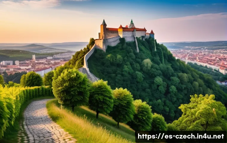 브르노의 역사적 명소 - A majestic medieval fortress perched on a hilltop overlooking a European city at sunset, featuring t...